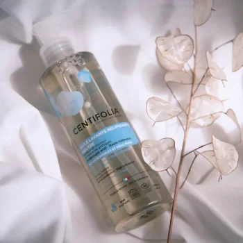 Frasco de óleo lavante relipidante Centifolia de 195ml sobre tecido branco, com folhas translúcidas decorativas ao lado.