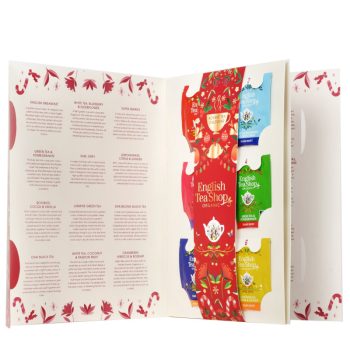 Calendário do advento em formato de livro da marca English Tea Shop, aberto, com 24 saquetas de chá e infusões biológicas em embalagens coloridas e lista de sabores à esquerda.