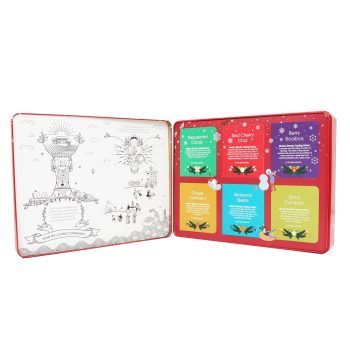 Lata Premium Holiday Collection da English Tea Shop aberta, mostrando seis compartimentos coloridos com diferentes blends de chá biológico, incluindo Peppermint Candy, Red Cherry Chai, Berry Rooibos, Ginger Cranberry, Seasonal Siesta e Spicy Pumpkin.