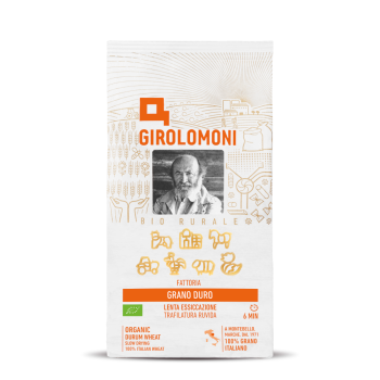 Embalagem de papel da massa biológica Girolomoni Fattoria, com figuras da quinta feitas de sémola de trigo duro 100% italiano, certificada biológica, secagem lenta e trafilatura rústica, peso 500g.